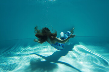 Woman in blue dress in zero gravity underwater