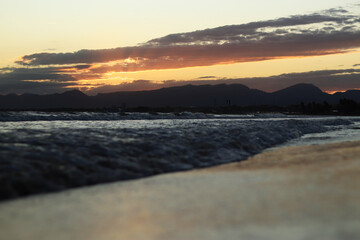 Sunset at sea. Balearic Sea, Salou, Spain. Beach, sea, small waves. Evening landscape on the coast....