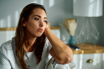 Young depressed woman sitting alone in  bedroom.