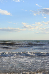 Sea view from the shore. Horizon on the sea. Balearic Sea, Salou, Spain. View of large waves on the sea from a low angle. Landscape. Stormy weather