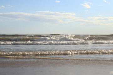 Sea view from the shore. Horizon on the sea. Balearic Sea, Salou, Spain. View of the waves on the sea with small waves from a low angle. Landscape