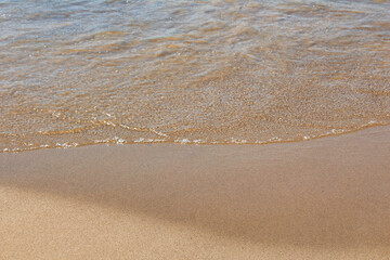 straight line wave clear washing up against the sand