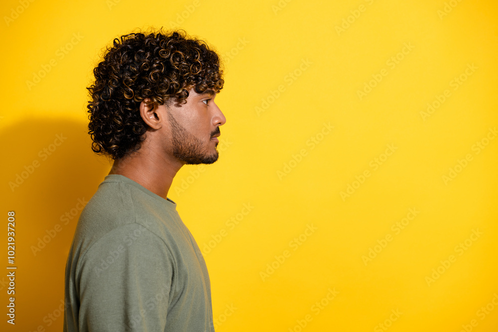 Sticker Side profile photo of serious guy with wavy hair dressed khaki t-shirt look at promo empty space isolated on yellow color background