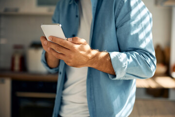 Close up of man using smart phone at home.