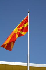 Macedonian Flag Waving on a Flagpole Against a Clear Blue Sky