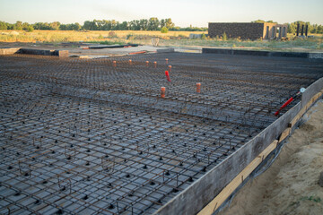 A steel-reinforced Swedish plate foundation is being constructed, with organized rebar laid out on...