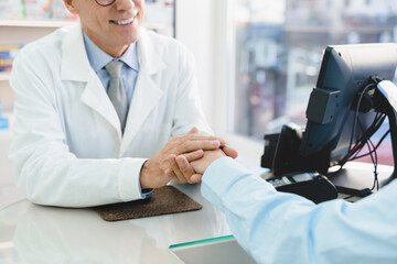 Closeup cropped mature male pharmacist doctor supporting, sympathizing female customer client buyer, listening attentively to her medical complaints in drugstore