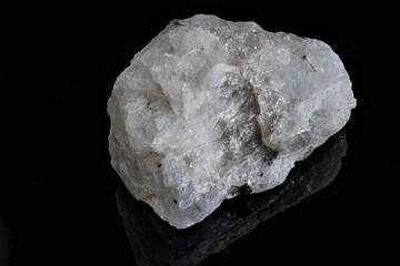 A raw moonstone fragment on a black background.
