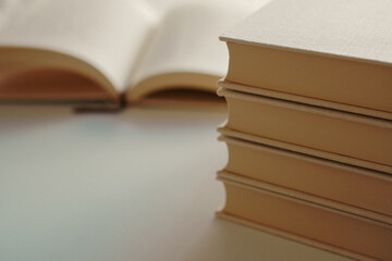 Stacked books on a white table with open blank book, mock-up	