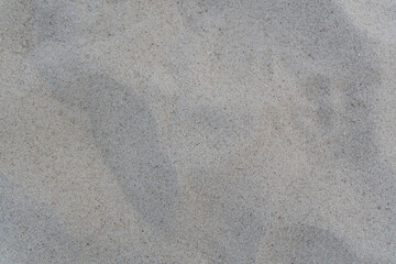Close-up texture of beach sand. A close-up of the surface of sea sand with gentle waves and natural...