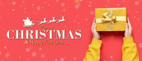 Female hands with Christmas gift on red background, closeup