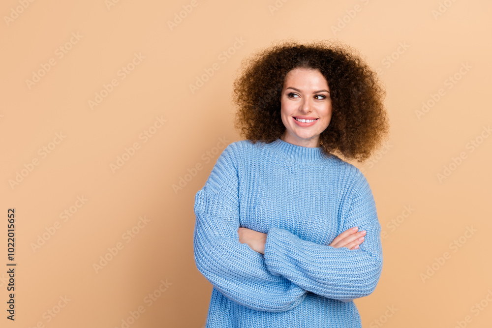 Canvas Prints Portrait photo of young beautiful curly haired lady smiling in blue knitted pullover folded hands look copyspace isolated on beige color background