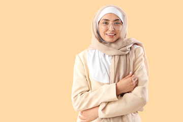 Fototapeta premium Young Muslim woman in stylish suit on beige background