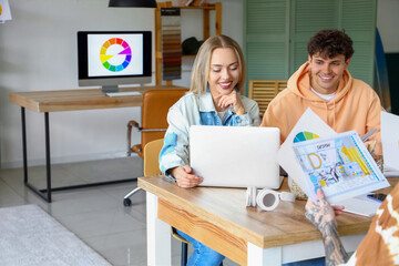Team of graphic designers working at table in office