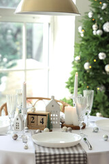 Festive table setting with burning candles and Christmas decor
