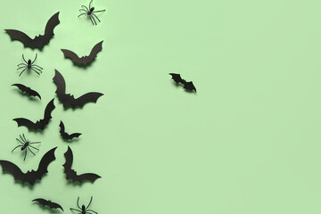 Paper bats and spiders for Halloween party on green background