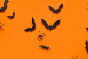 Paper bats and spider for Halloween party on orange background