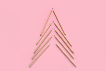 Christmas tree made of colorful pencils on pink background