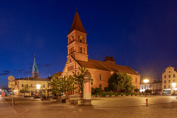 Early morning view of St. Catherine's Church on the market square illuminated by street lamps, Torun, Poland