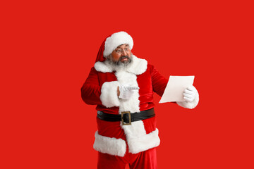 Santa Claus reading letter on red background