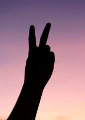 person with finger pointing at the sky sunset