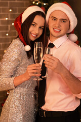 Young couple with champagne celebrating New Year at party
