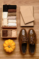 Basic color socks with stylish shoes, books and pumpkin on wooden background