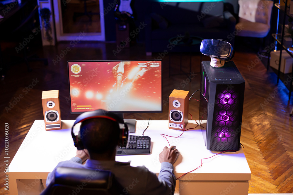 Aufkleber man playing sf shooter videogame on computer monitor, talking into headset with friends. gamer using