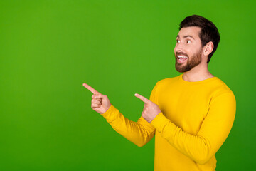 Photo portrait of attractive young man point look empty space dressed stylish yellow clothes isolated on green color background