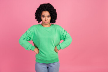 Portrait photo of young charming woman with chevelure in green sweatshirt touch waist grumpy isolated on pink color background