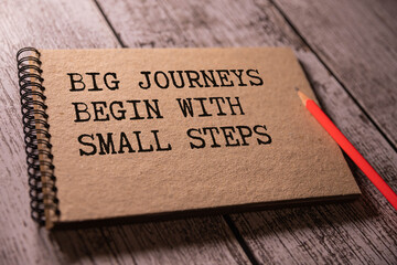 Big journeys begin with small steps. Text on notebook. Inspiring Creative Motivation Quote