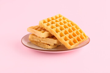Plate with delicious Belgian waffles on pink background