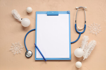 Stethoscope with clipboard and Christmas decor on beige background