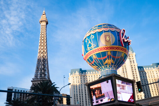 Las Vegas, NV - USA: The Eiffel Tower and Paris Hot Air Balloon during golden sunset on the Las Vegas Strip. Sunlight and shadows, blue sky.  