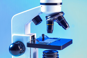 Modern microscope on blue background