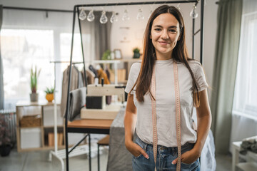 Adult woman tailor or fashion designer stand and work on sewing machine