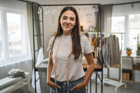 Adult woman tailor or fashion designer stand and work on sewing machine