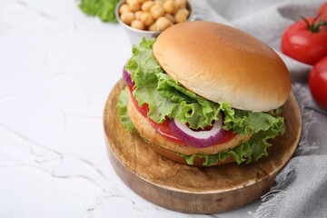 Delicious vegetarian burger with chickpea cutlet on white table, closeup