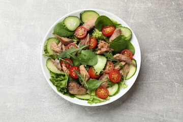 Delicious fresh tuna salad on grey table, top view