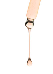 Cosmetic oil dripping from pipette on white background, closeup