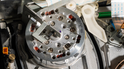 A small silver object with a black handle is being used to remove a small object video head