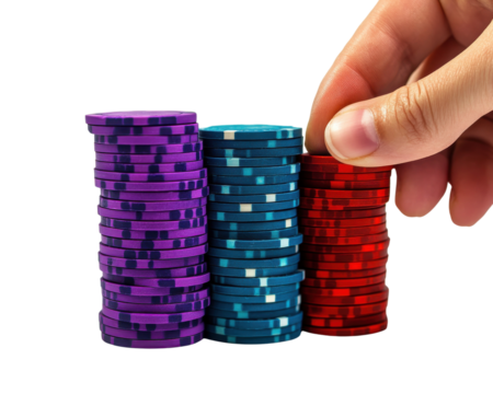 Stacks of poker chips in various colors with a hand placing a red chip.