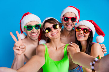 Photo of happy people couple girlfriends boyfriends make selfie on new year resort isolated blue color background