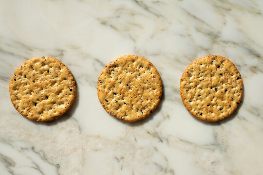 three round multigrain crackers on white marble