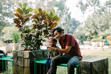 A father and his child sitting and chatting in a city square