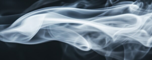 Obraz premium Elegant swirl of white smoke gracefully dancing against a dark background, creating a mesmerizing abstract visual.