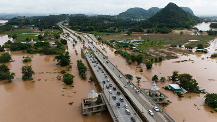 Aerial view of car driving on the bridge after road flooded during typhoon Yagi has swept Chiang Rai province of Thailand.