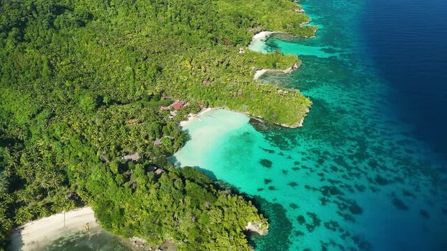 INDONESIA - 9.4.2024 - Great aerial footage circling counterclockwise towards the shore of Indonesia's tree-covered Malenge Island.