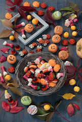 Wooden Halloween candy board. Holidays and Food. Dessert in shape of pumpkin, skull, witch. 