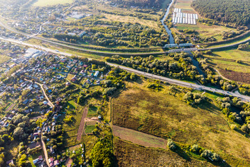 Fototapeta premium High altitude view of the ground with a railway and a highway crossing a river